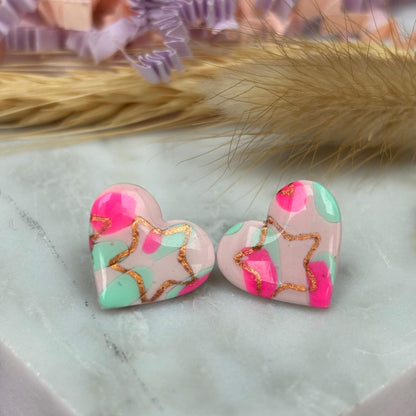 Charming heart stud earrings in pink and mint with a subtle rose gold star detail.
