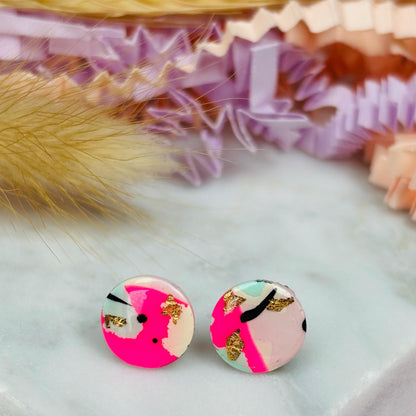 Vibrant 90s-inspired stud earrings with a neon pink, mint, and black ink design, handmade with polymer clay.