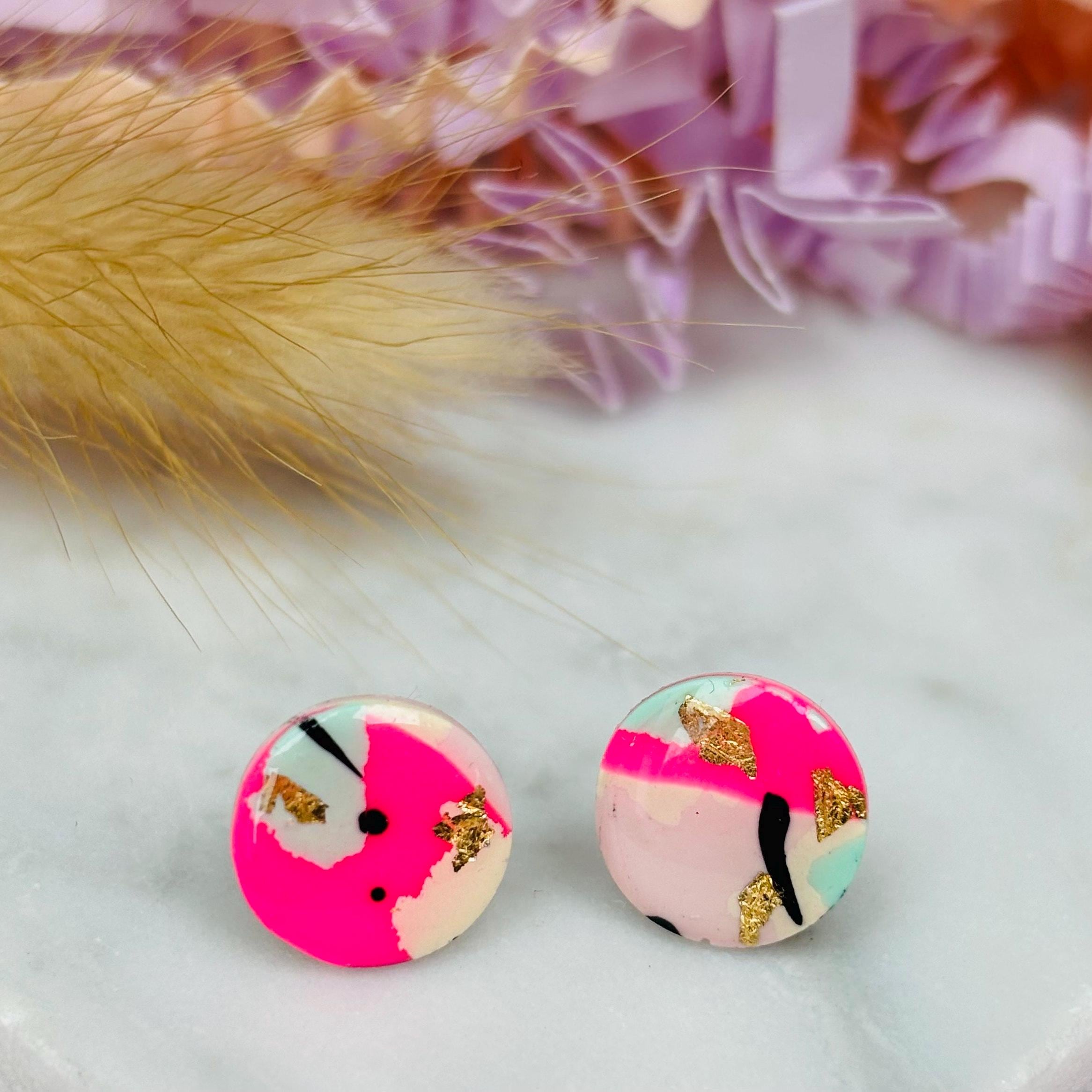 Vibrant 90s-inspired stud earrings with a neon pink, mint, and black ink design, handmade with polymer clay.