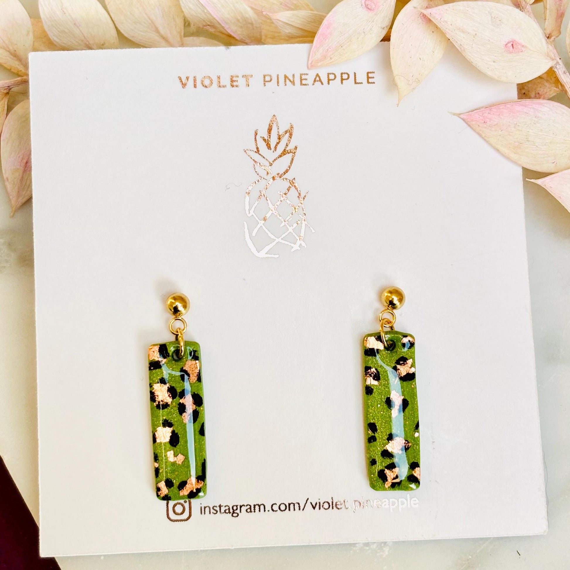Elegant leopard print drop earrings with gold foil accents, hand-painted and handmade with polymer clay.