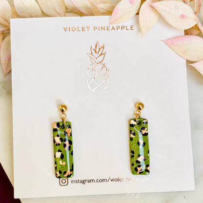 Elegant leopard print drop earrings with gold foil accents, hand-painted and handmade with polymer clay.