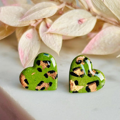 Elegant heart-shaped stud earrings with a hand-painted leopard print, handmade with polymer clay.