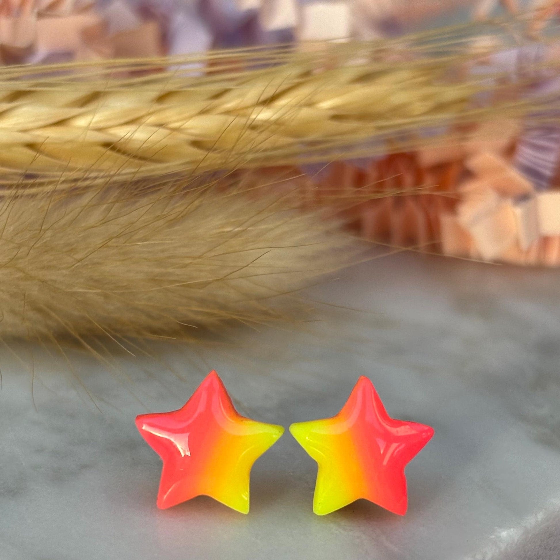 Quirky surf chic inspired mini star stud earrings with a bright pink and yellow ombré blend, handmade with polymer clay.