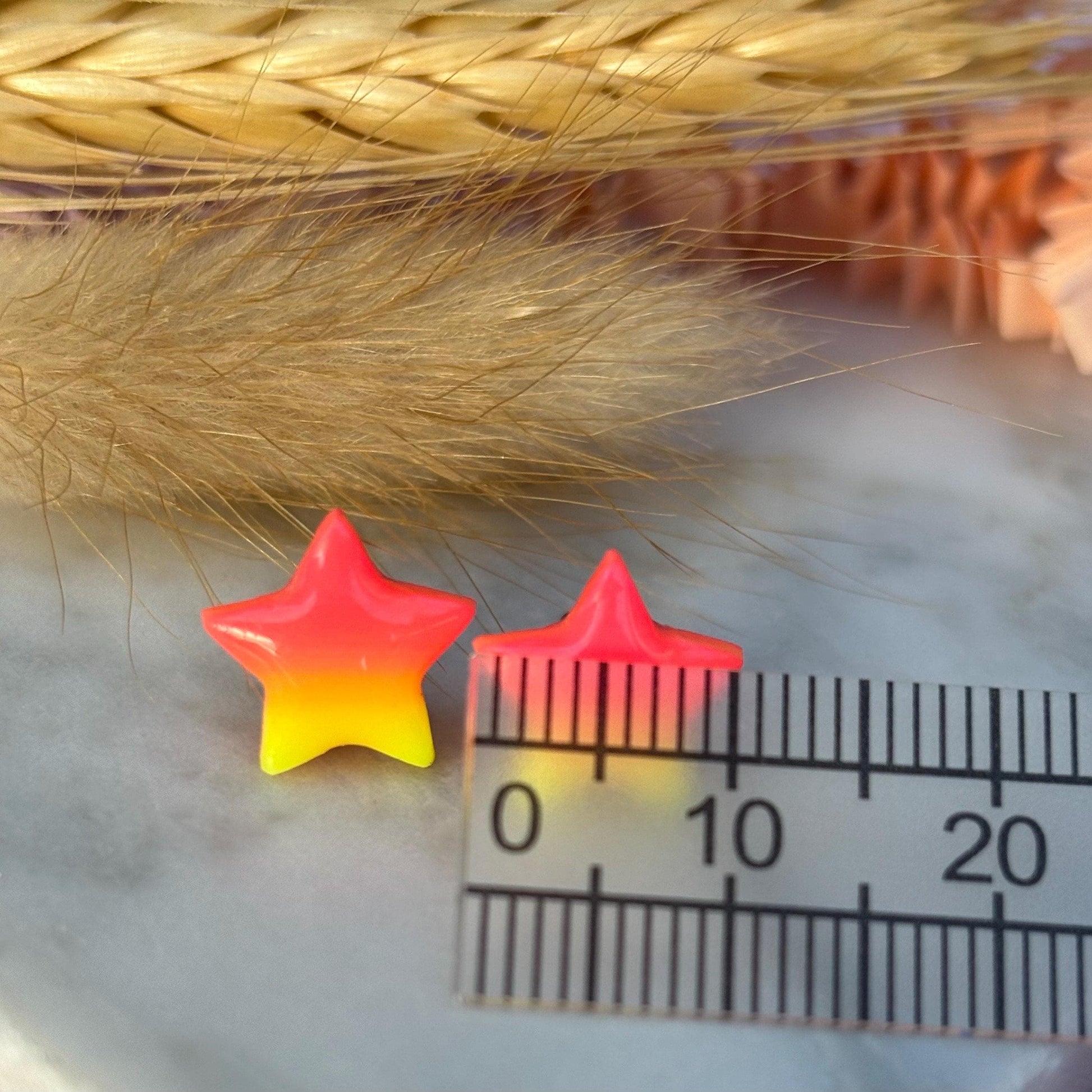 Quirky surf chic inspired mini star stud earrings with a bright pink and yellow ombré blend, handmade with polymer clay.