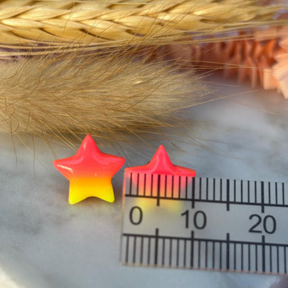 Quirky surf chic inspired mini star stud earrings with a bright pink and yellow ombré blend, handmade with polymer clay.