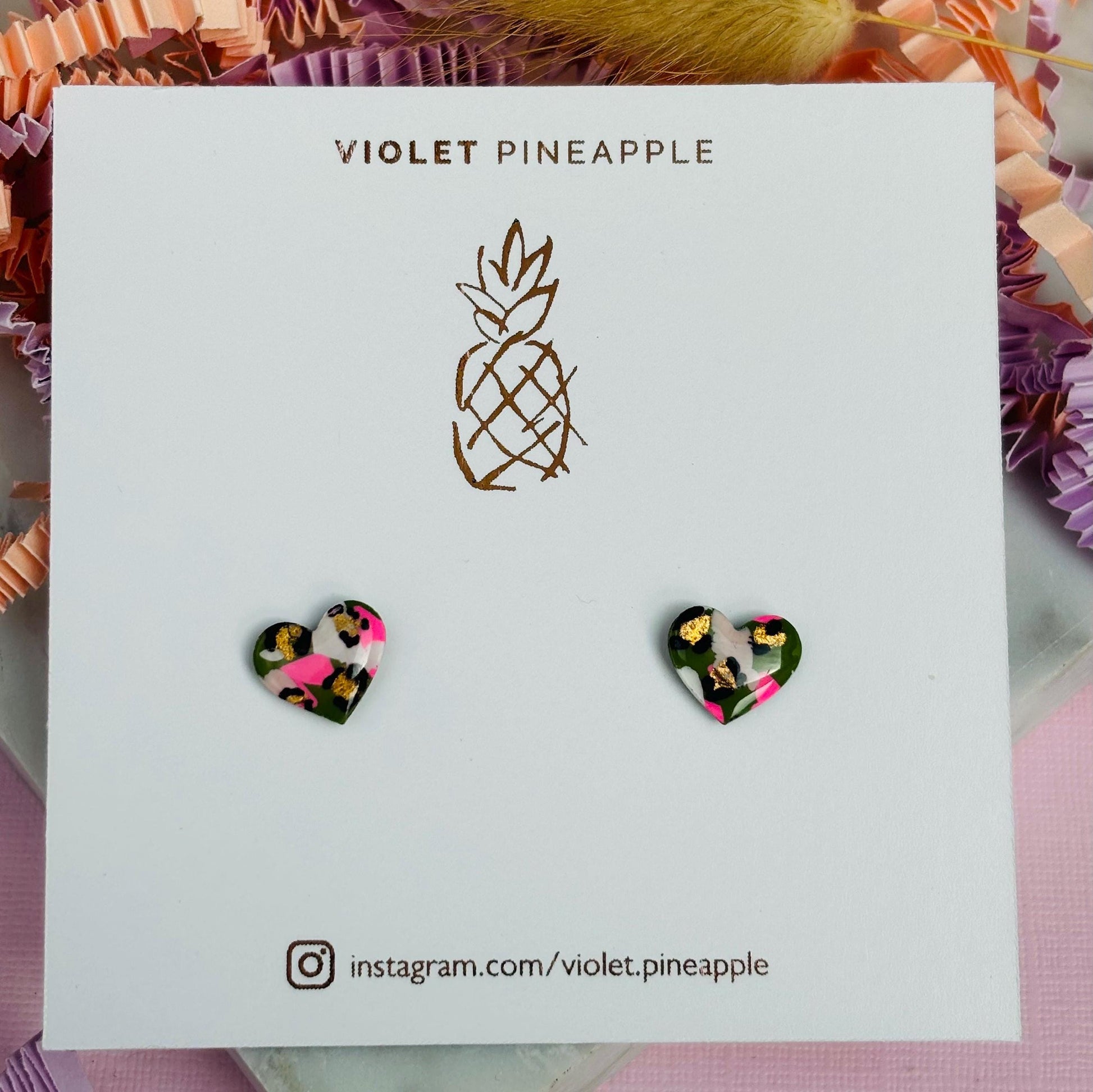 Small leopard print heart stud earrings in green and pink.