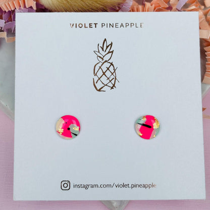 Vibrant 90s-inspired stud earrings with a neon pink, mint, and black ink design, handmade with polymer clay.
