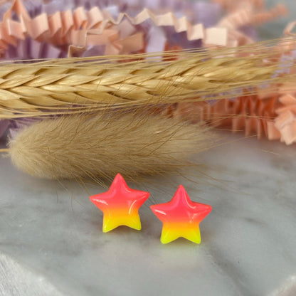 Quirky surf chic inspired mini star stud earrings with a bright pink and yellow ombré blend, handmade with polymer clay.
