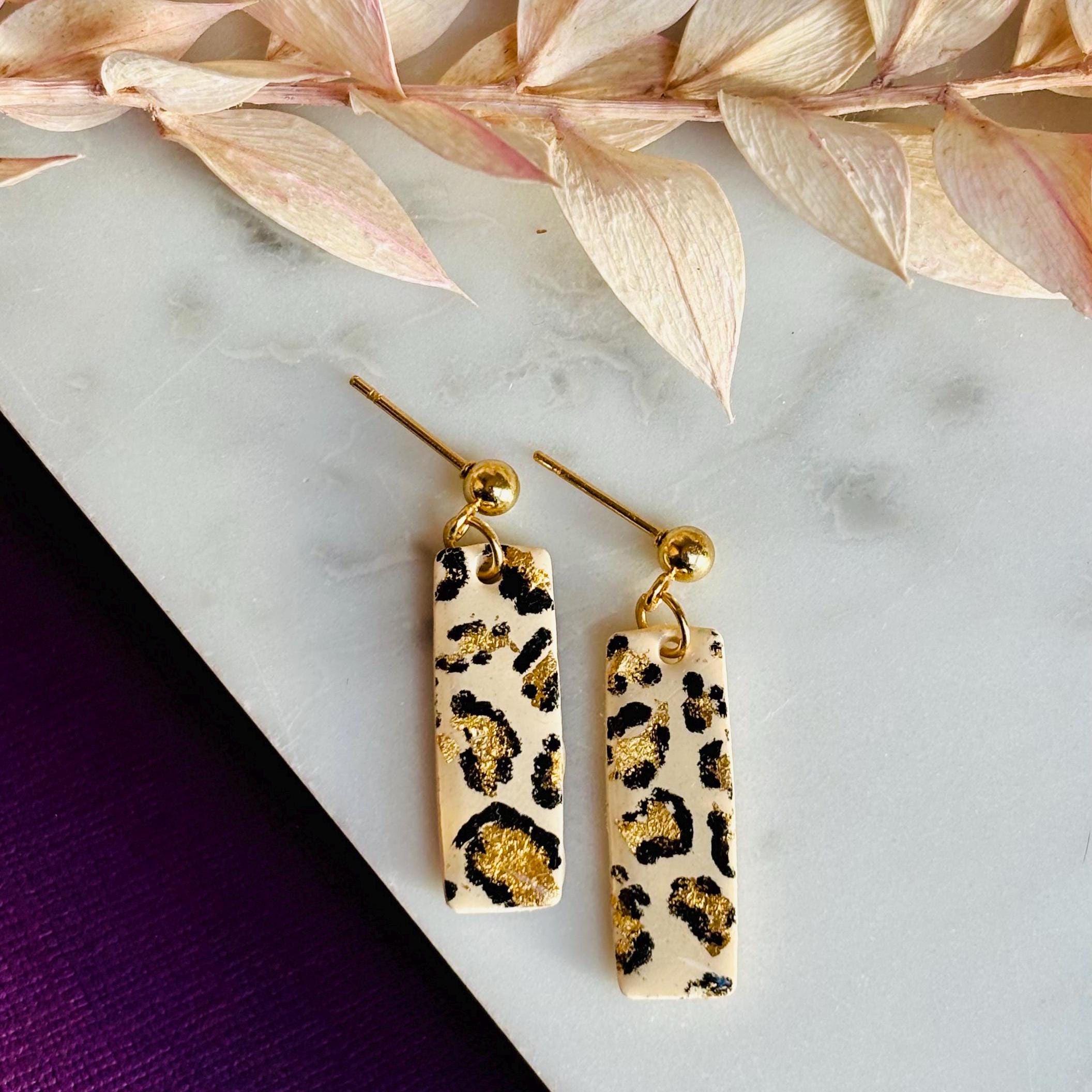 Elegant leopard print drop stud earrings with neutral tones and gold accents, hand-painted and handmade with polymer clay.