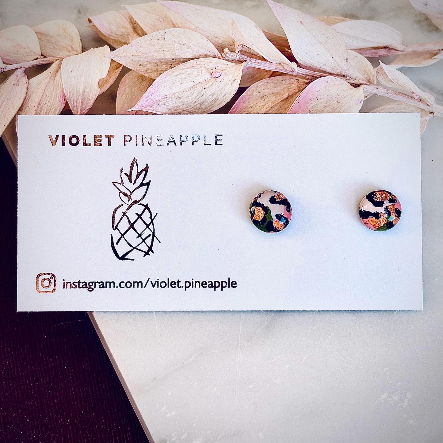 Petite leopard print stud earrings, 8mm x 8mm, with hand-painted spots in olive green and peach tones, handmade from polymer clay.