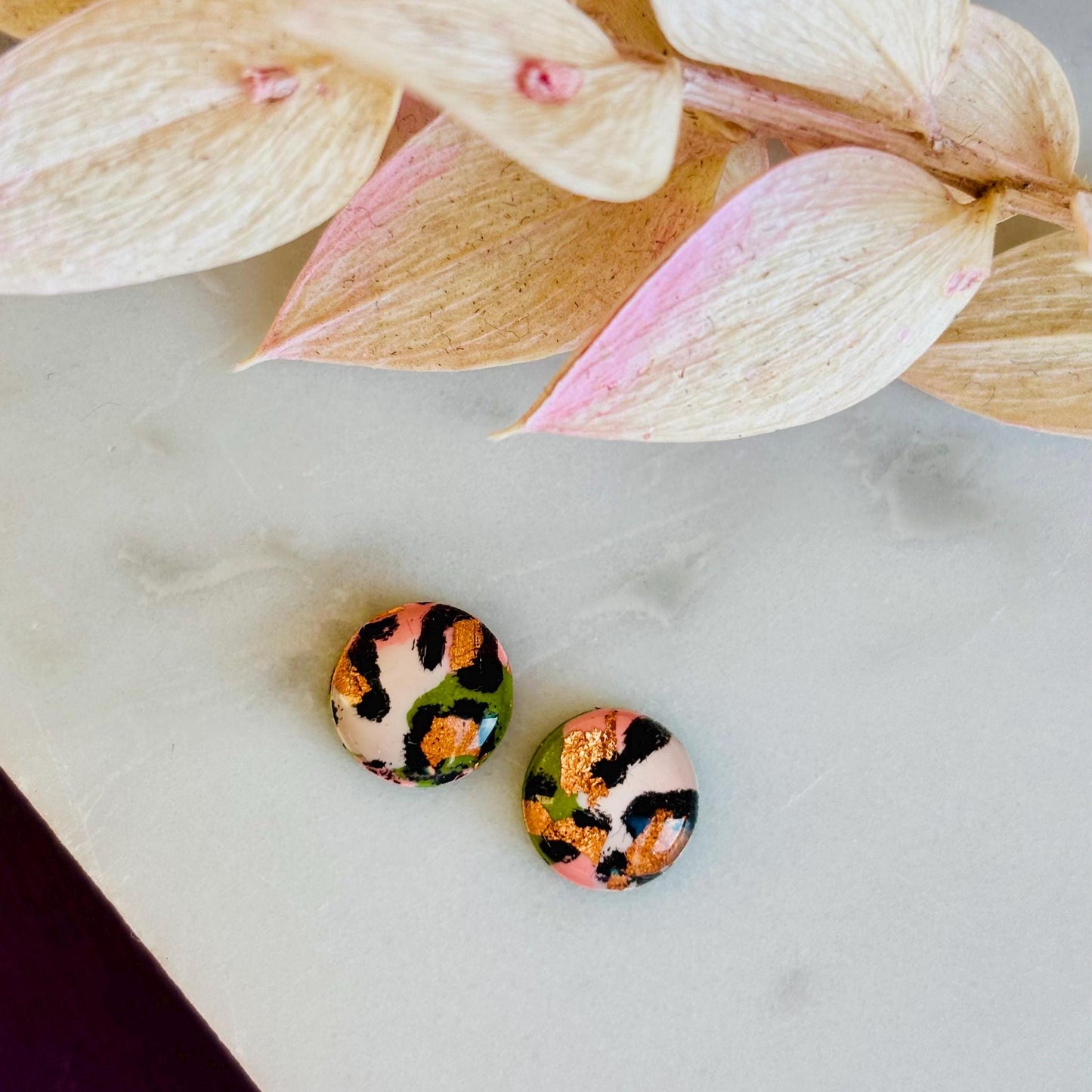 Petite leopard print stud earrings, 8mm x 8mm, with hand-painted spots in olive green and peach tones, handmade from polymer clay.