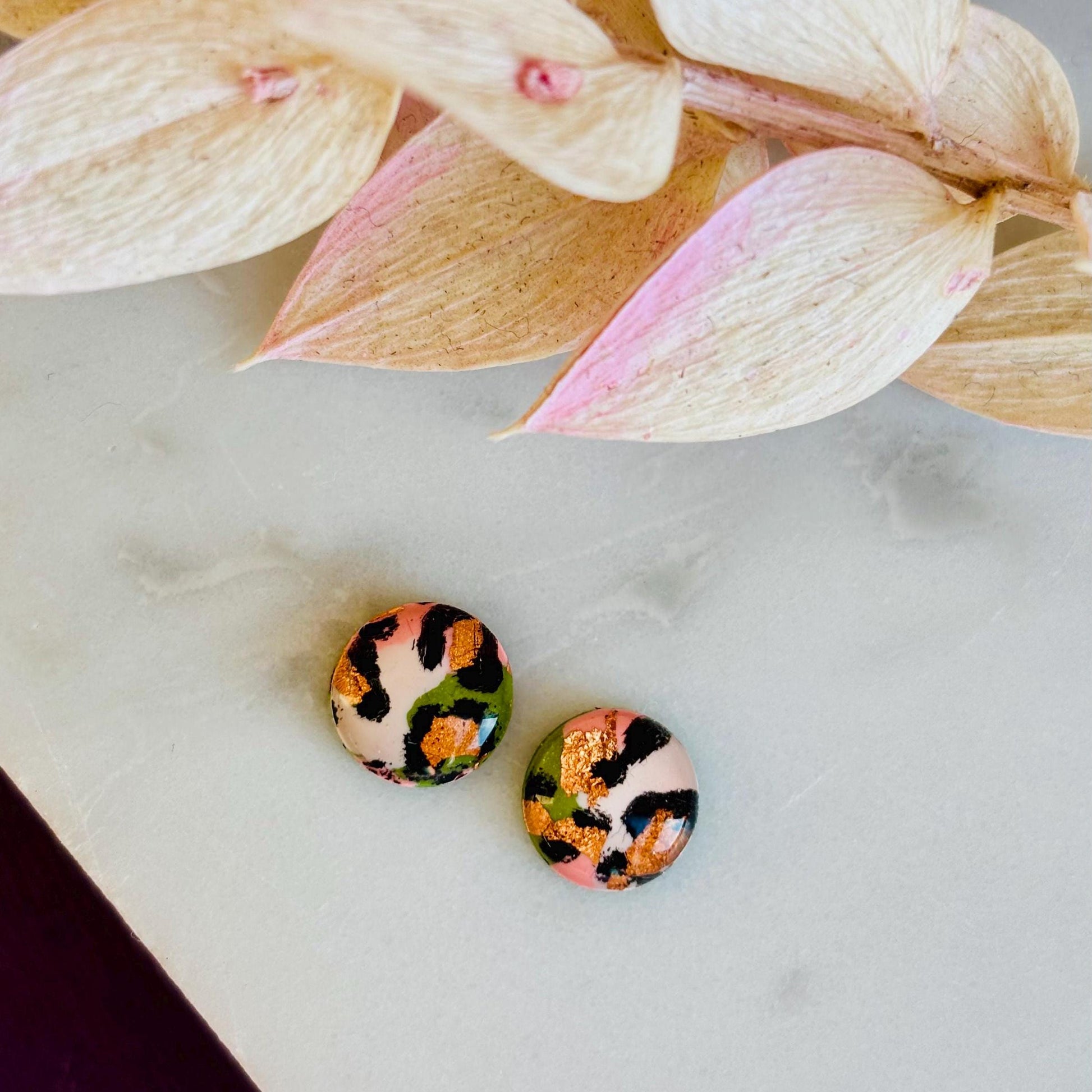 Petite leopard print stud earrings, 8mm x 8mm, with hand-painted spots in olive green and peach tones, handmade from polymer clay.