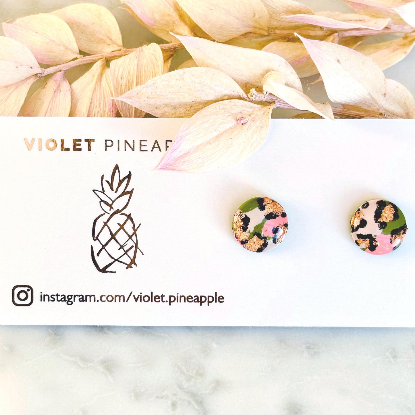 Vivid leopard print stud earrings, 10mm x 10mm, with hand-painted spots in peach, olive green, and rose gold, handmade from polymer clay.