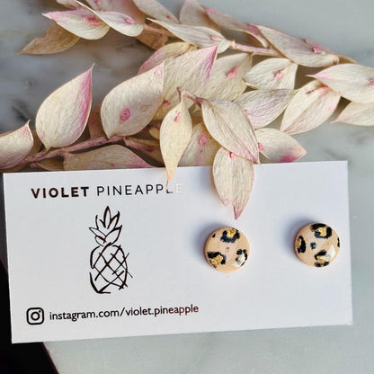 Elegant leopard print drop stud earrings with neutral tones and gold accents, hand-painted and handmade with polymer clay.