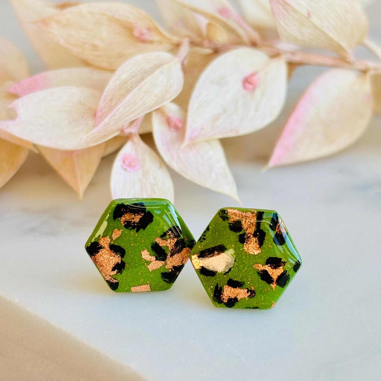 Leopard print hexagon stud earrings with hand-painted spots, handmade with polymer clay. 15mm x 15mm.