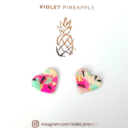 Vibrant 90s punk-inspired heart-shaped stud earrings, handmade with polymer clay. Features neon pink, mint, black ink, and gold leaf accents.