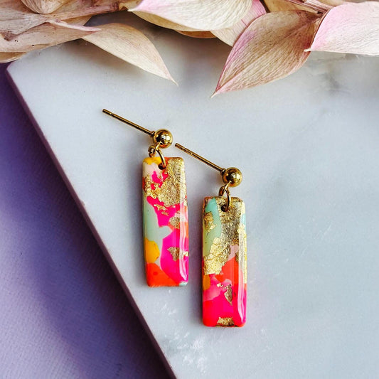 Colourful surf-inspired drop stud earrings with gold foil detail, handmade from polymer clay, featuring hypoallergenic surgical stainless steel posts and backings.