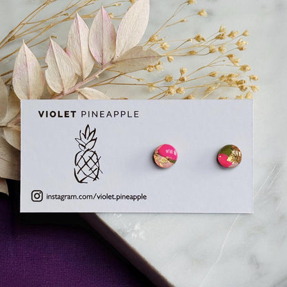 Pair of round earrings with pink and gold accents on a 'Violet Pineapple' branded card.