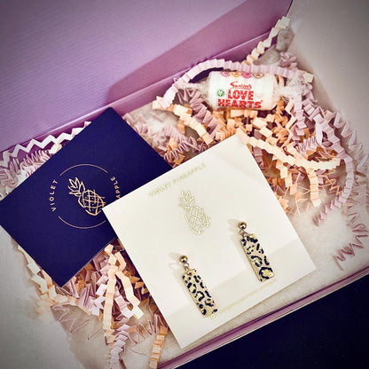 Leopard print earrings in a decorative box with a card and candy.