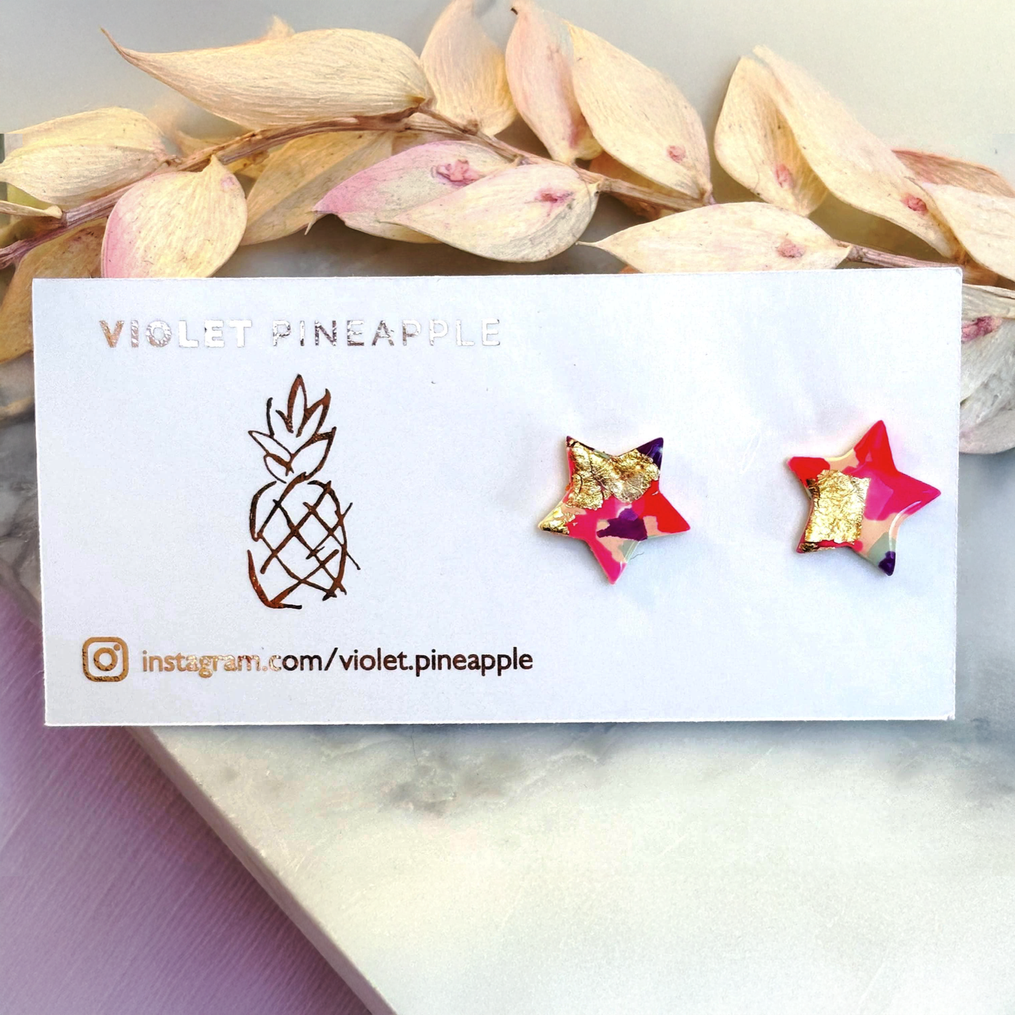 Pair of vibrant handmade star stud earrings featuring a playful mix of pink, mint, and gold colours.