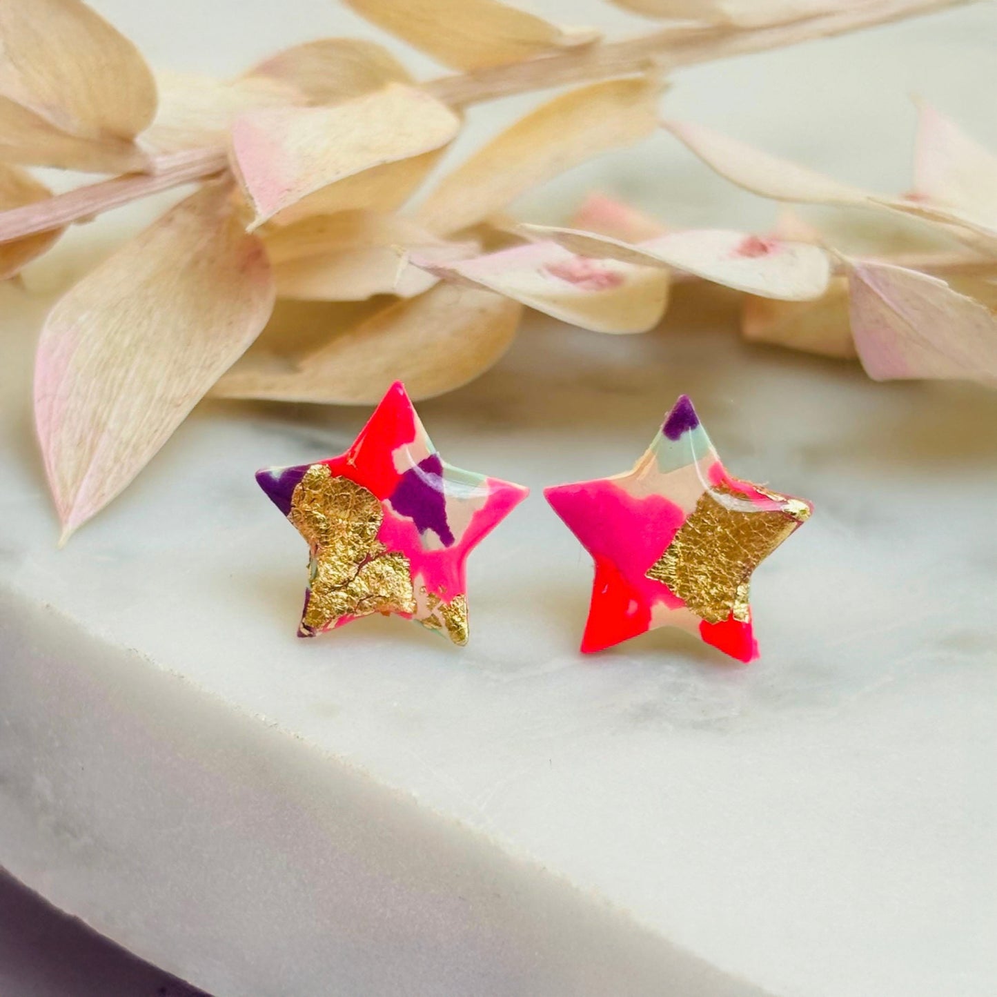 Pair of vibrant handmade star stud earrings featuring a playful mix of pink, mint, and gold colours.