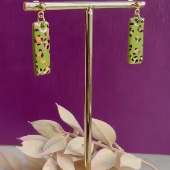 Elegant leopard print drop earrings with gold foil accents, hand-painted and handmade with polymer clay