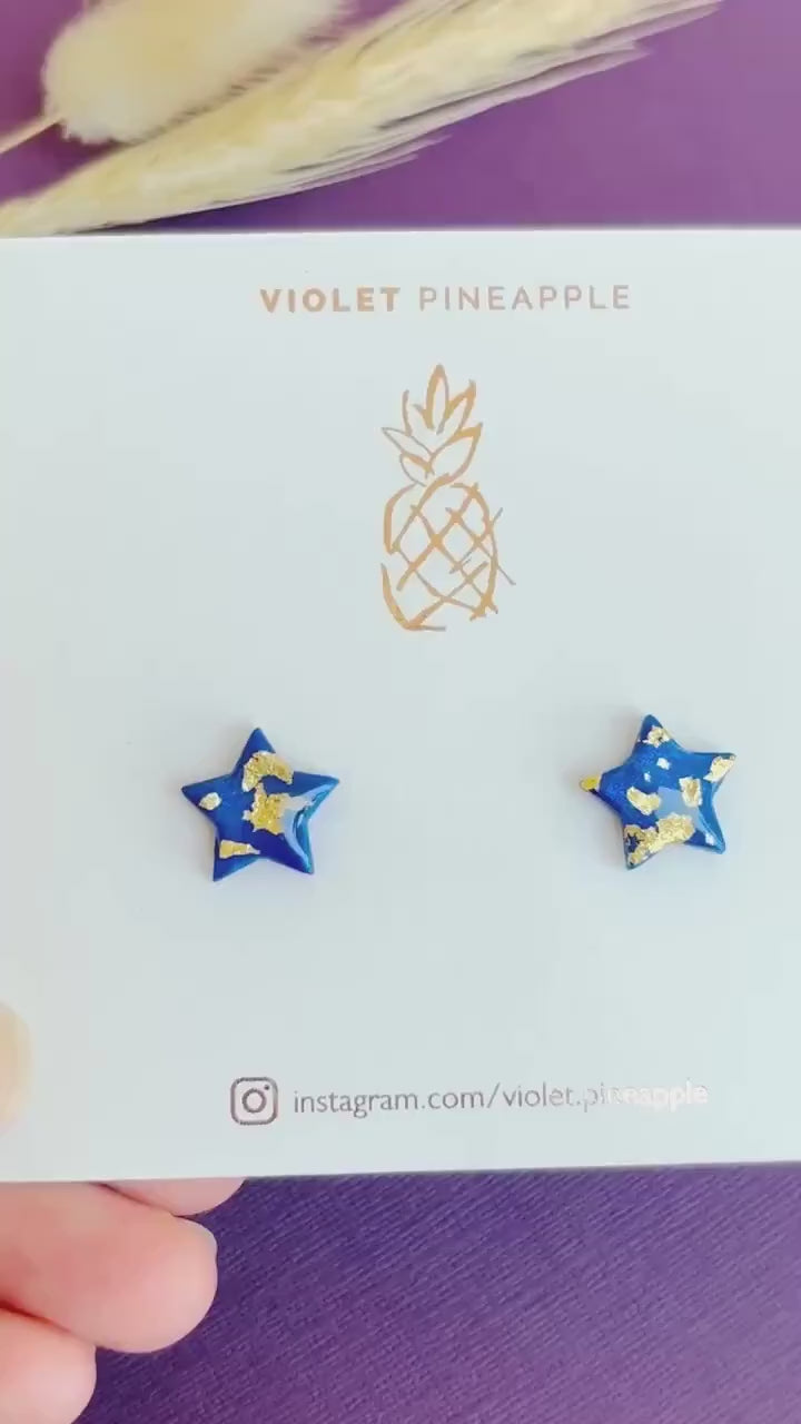 Chic navy blue star-shaped stud earrings with gold foil detailing, handmade with polymer clay