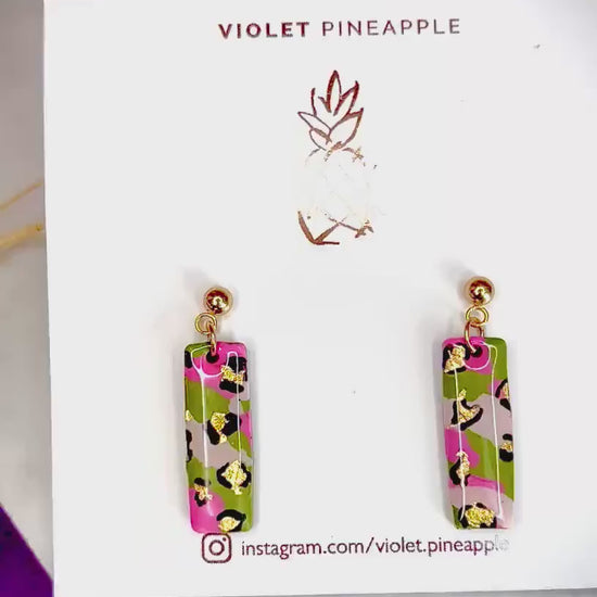 Elegant leopard print drop earrings with gold foil accents, handmade with polymer clay.