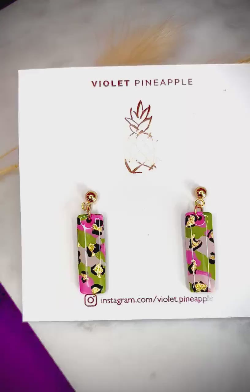 Elegant leopard print drop earrings with gold foil accents, handmade with polymer clay.