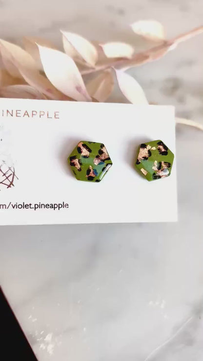 Leopard print hexagon stud earrings with hand-painted spots, handmade with polymer clay.